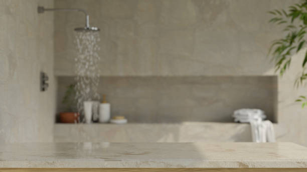 istock Copy space on stylish marble tabletop over blurred modern loft bathroom with rain shower 1389649971