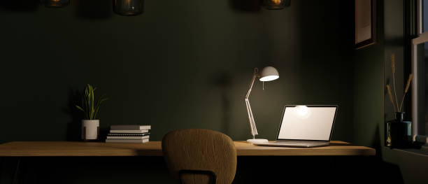 istock Modern Scandinavian dark office workspace with laptop computer. Workspace at night. 1389650000