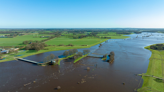 High water level in the river Vecht at the Vechterweerd weir in the Dutch Vechtdal region in Overijssel, The Netherlands. The river is overflowing on the floodplains after heavy rainfal upstream in The Netherlands and Germany during storm Eunice and Franklin in February 2022.