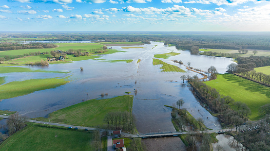 High water level in the river Vecht at the Junne weir in the Dutch Vechtdal region in Overijssel, The Netherlands. The river is overflowing on the floodplains after heavy rainfal upstream in The Netherlands and Germany during storm Eunice and Franklin in February 2022.