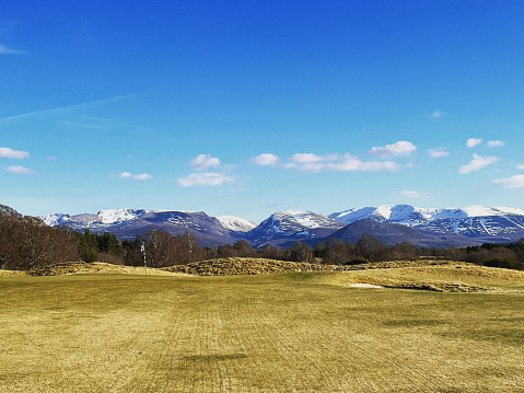 A shot of the scene up the 18th fairway at championship course Spey Valley in Aviemore, Scotland. Larig Ghru and Cairngorm Mountain in the background.