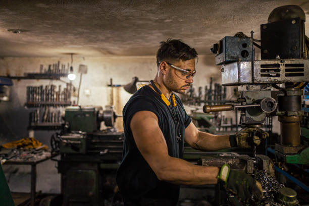 istock Worker making few adjustment on a milling machine at the metal workshop 1389651934