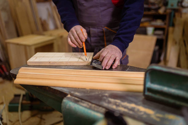 istock Male carpenter with pen marks the design on the timber 1389651974