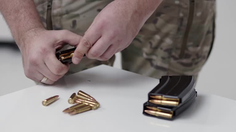 A man close up loading a machine gun clip with ammunition. Preparation for shots and war