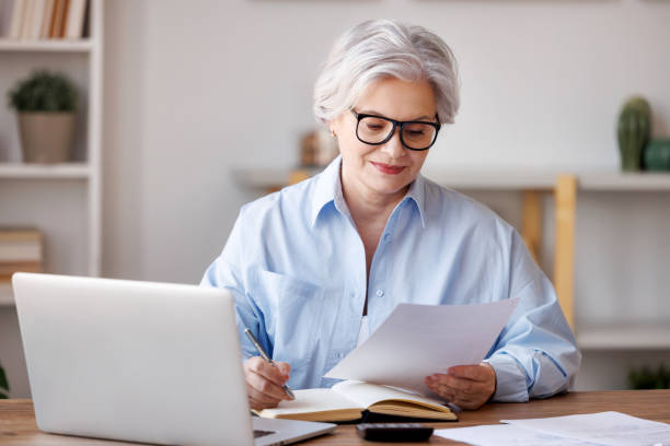 istock Focused middle aged businesswoman working in home office 1389652079