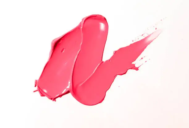 Pink matte lipstick, smear texture on a white isolated background