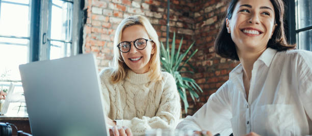 Two pretty women working in loft office together stock photo