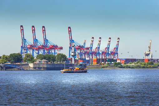 Hamburg, Germany - July 26, 2018: Harbor freight shipping cranes on Elbe river