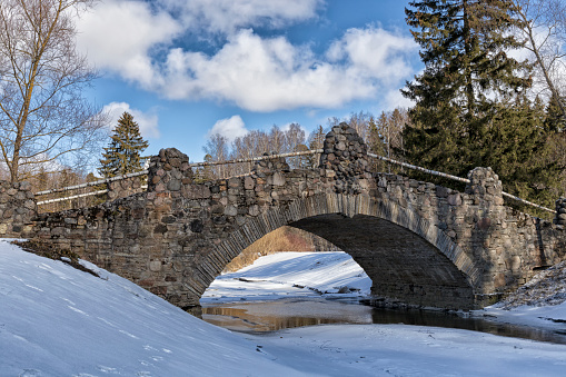 Ancient one-arch stone bridge during early spring (Pavlovsk, Saint Petersburg, Russia)