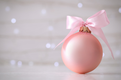 Beautiful Christmas ball on table against blurred festive lights. Space for text