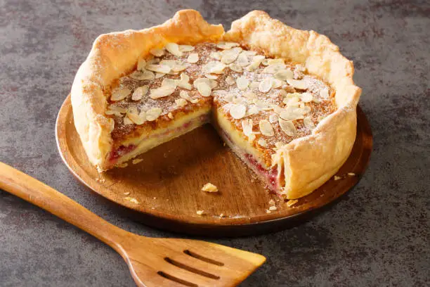 Bakewell puddings are a traditional dessert made from a pastry base with a layer of jam topped with a filling of egg and almond paste closeup on the table. Horizontal