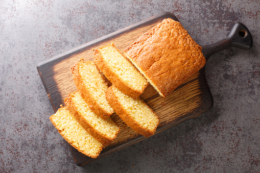 Delicious tender Madeira biscuit cake close-up on a wooden board on the table. horizontal top view from  above