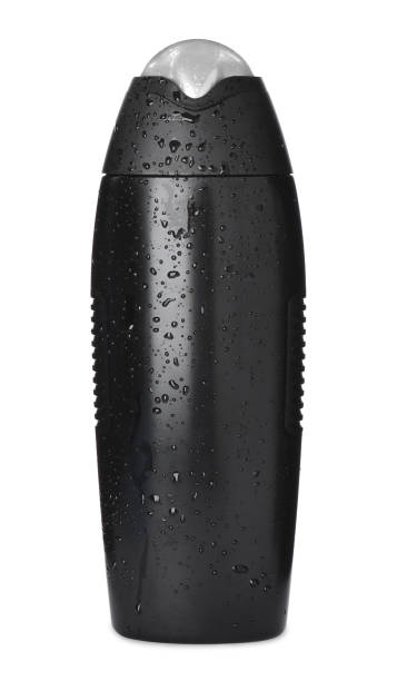 istock Black bottle covered with water drops isolated on white. Men's cosmetics 1389669566