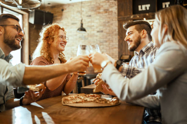 istock Group of people eating pizza drinking beer 1389670235