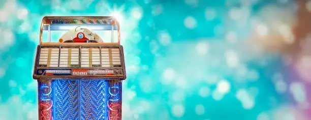 Vintage colorful jukebox in front of blue background with bokeh
