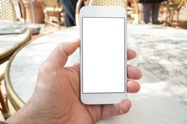 POV shot using a smart phone with blank screen on a cafe terrace in France. White screen for insertion of graphic.