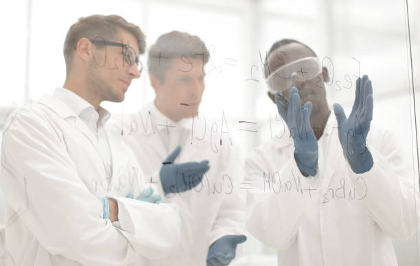 istock group of scientists talking standing near a glass Board 1389676711