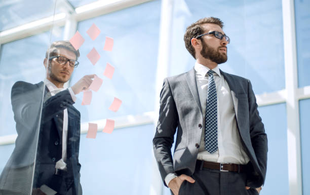 istock employees standing near a transparent office wall 1389678308