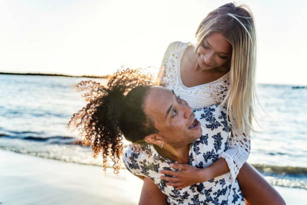 verano hermosa pareja multiétnica riendo, divirtiéndose juntos, saliendo en la playa.  gente enamorada. luna de miel. - honeymoon beach couple heterosexual couple fotografías e imágenes de stock