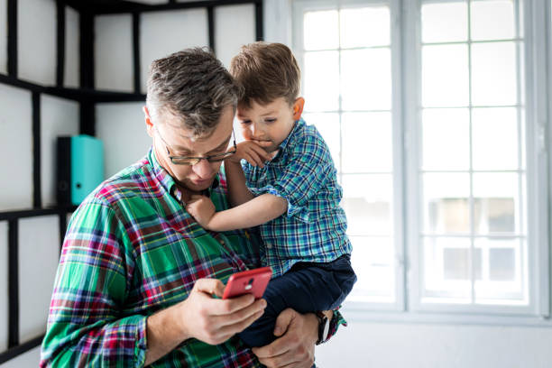 istock Father and son using smart phone at home 1389680065