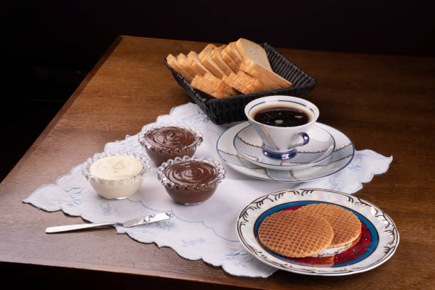 crèmes aux noisettes, au chocolat et au chocolat blanc avec gaufres sur une table de tasse de petit-déjeuner et un panier à pain - coin chocolate food chocolate coin photos et images de collection