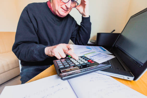 istock Worried senior man checking bills at home 1389681930