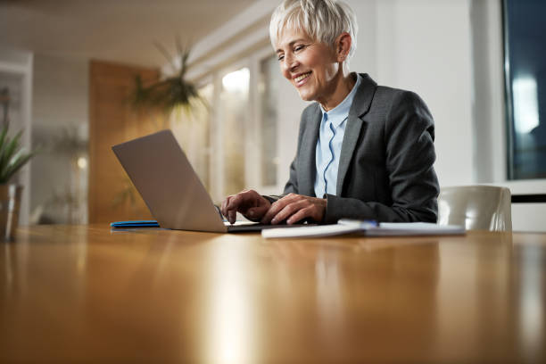 istock Happy mature entrepreneur typing an e-mail on a computer at home office. 1389683123