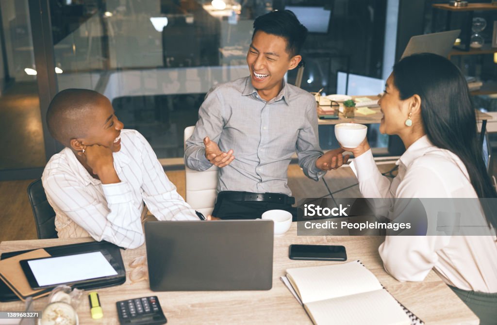 Shot of a group of businesspeople working late in a modern office A much needed break Coffee - Drink Stock Photo