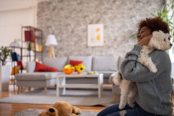 istock Woman Black ethnicity embracing her Maltese dog 1389683312