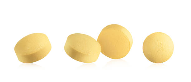 Yellow round pills on white background