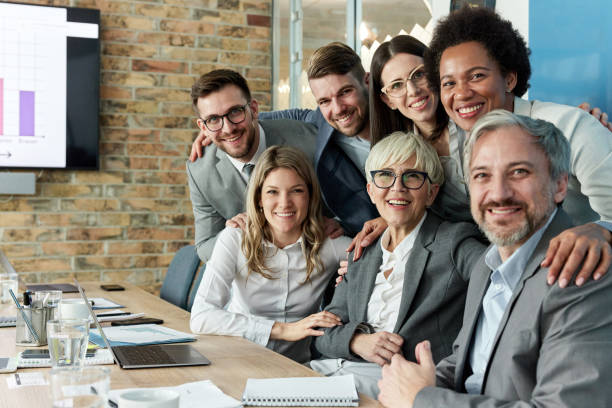 istock Happy business team embracing in the office. 1389683679