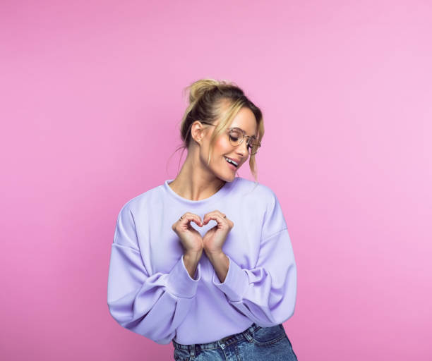 istock Smiling woman gesturing heart shape 1389683844