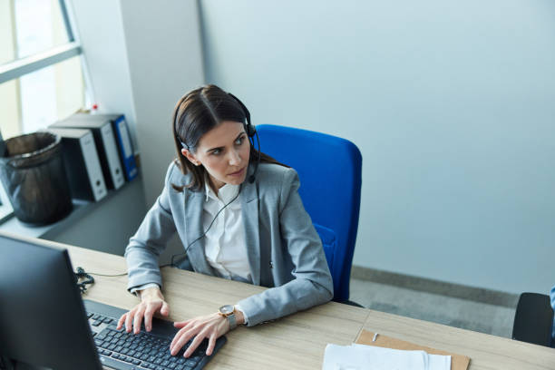 istock Female customer service representative working on PC in a call center. 1389684568