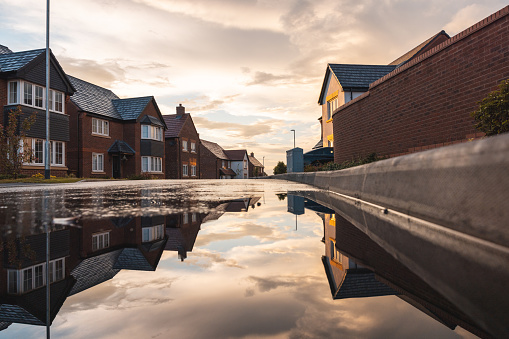 Houses in a new development estate in England and reflection on a puddle of water
