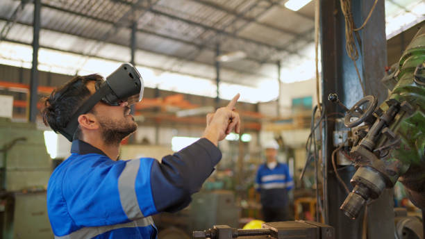 istock Engineer wearing virtual reality headset standing in the manufacturing factory. Moving hand and looking around the data. Working with Holographic Animations. High technology and industrial concept 1389684998