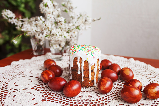 Traditional  Easter cake with icing and hand painting eggs. Homemade muffins with powdered sugar. Rustic style, religion