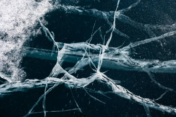 istock Transparent blue ice with cracks on Baikal lake in winter. 1389691843