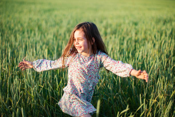 istock Little girl having fun in summer field 1389692449