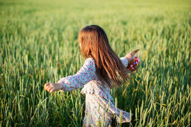 istock Little girl having fun in summer field 1389692503