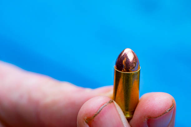Close-up of man holding a 9 mm bullet.