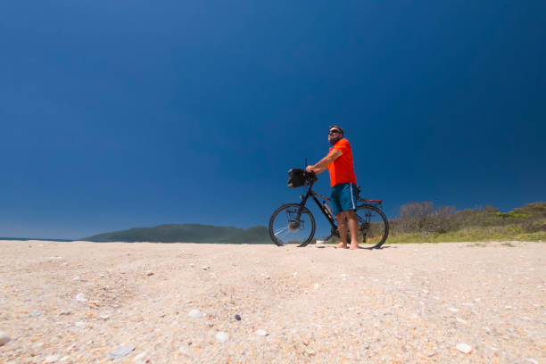 Man with a touring bike at Armação beach on Santa Catarina island in southern Brazil