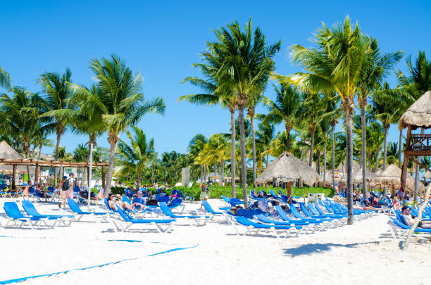 Crowd lying on chaise longue on the beach of Playa del Carmen during day of March