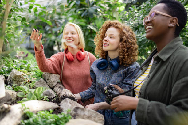 pequeño grupo diverso de mujeres que visitan un invernadero local en la ciudad - jardín botánico fotografías e imágenes de stock