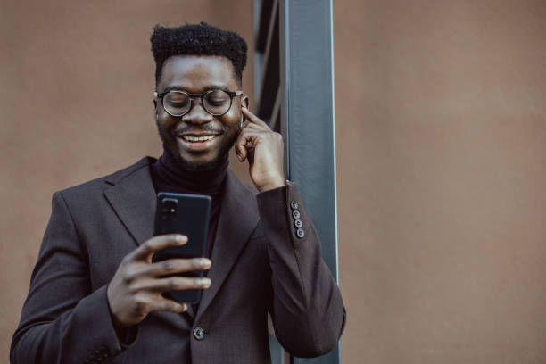 istock Smiling young multiracial man looking at his smart phone 1389698640