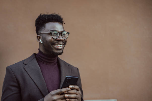istock Man holding mobile phone and looking away 1389698644
