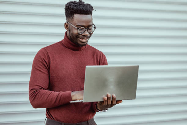 istock Businessman using laptop outdoors 1389698748