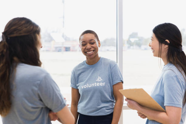 istock Three female volunteers enjoy talking together at community event 1389699480