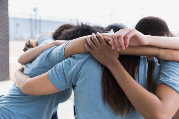 istock After event, diverse volunteers huddle together 1389699511