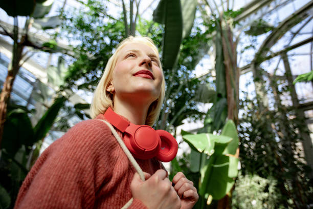 feliz joven caucásica explorando un jardín de invernadero local - environmental conservation audio fotografías e imágenes de stock