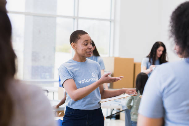 istock Mid adult woman gestures while training volunteers for community event 1389699617